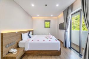 a bedroom with a large bed and a phone at Green LP Hotel & Apartment in Vung Tau