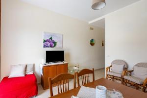 een kamer met een bed en een bureau met een televisie bij Villa Rosa by Rentbeat in Montalbano