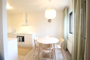 a kitchen and dining room with a white table and chairs at Forenom Serviced Apartments Hämeenlinna Katuma 8 in Hämeenlinna