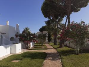 a pathway with trees and flowers in a yard at Villa Blue - Aldeia do Golfe in Quarteira