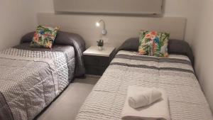 una camera con due letti e un comodino di Casa ARCO IRIS avec Jardin et Terrasse - piscine et jacuzzi partagés - by Cathy Ducoin a San Juan de los Terreros Altre 37 foto