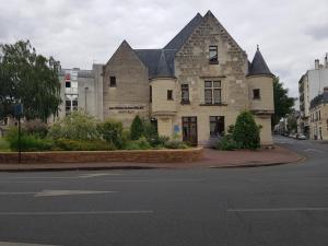 - un vieux bâtiment en pierre au coin d'une rue dans l'établissement Maison cosy citadine, à Tours