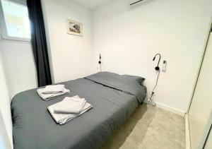 una camera da letto con un letto con asciugamani sopra di Au bord de l'eau - Appartement cosy au Cap d'Agde a Cap d'Agde