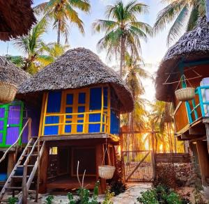 a colorful house with palm trees in the background at CocoKabanasRote in Nembrala