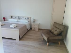 a bedroom with a bed and a chair at Dalla Gina e Paolino B&B in Aulla