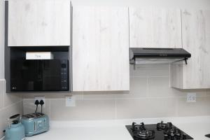 a kitchen with a microwave oven and a stove at Blessing Suite- Serenity and Stuff Luxury Apartments in Midrand +6 photos