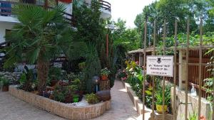 a garden center with plants and trees and a sign at Guest House Urdoviza in Kiten