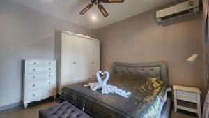 a bedroom with a bed with a swan decoration on it at Villa Grace in Ban Pak Khlong Phe
