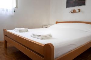 a bed with white sheets and towels on it at Kornati Paradise Residence Slanica in Murter