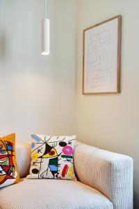 Una sala de estar con un sofá con almohadas. en Lovely Studio, en Boulogne-Billancourt