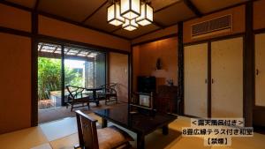 a living room with a table and a dining room at Omoideno Jinde in Izu
