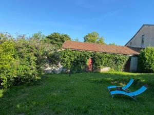 a blue bench sitting in the grass in a yard at Gîtes les Perouilles - La grange d'Angèle in Puymiclan