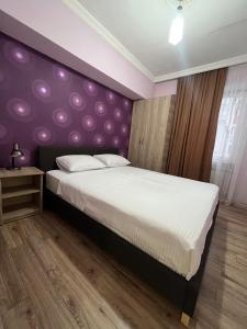 バトゥミにあるCozy Apartmentのベッドルーム(紫色のヘッドボード付きの大型ベッド1台付)