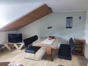 a living room with a wooden table and chairs at Ferienwohnung Katrin Spindler in Ilmenau