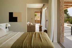 a bedroom with a bed and a living room at the Wildt - Exclusive Coastal Living in Argostoli