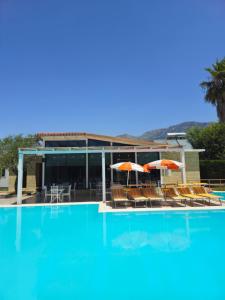 a large swimming pool with chairs and umbrellas at Resort Te Zagolli in Orikum