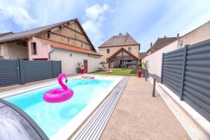 a swimming pool with a pink flamingo in a backyard at Chez Laurence in Saint-Aubin
