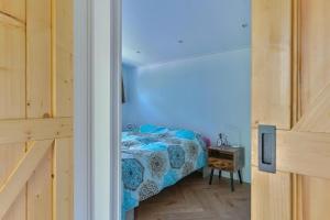 a small bedroom with a bed with a blue light at Luxe Lodge voor 4 personen - Rolstoel-toegankelijk in Hoogersmilde