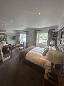 a bedroom with a large bed and a desk with a lamp at Long Quay House in Kinsale