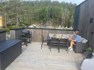 a woman sitting at a table on a patio at Arendalsuka Vacation Norway in Froland Verk