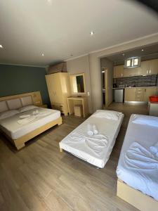 two beds in a room with a kitchen at ANGELA STUDIOS in Parga +4 photos