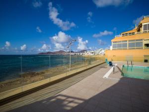 a building next to a beach with the ocean at Canteras Horizon By CanariasGetaway in Las Palmas de Gran Canaria