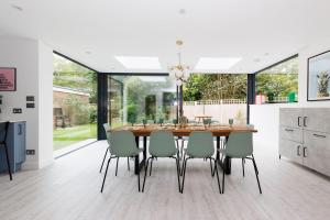 a kitchen and dining room with a wooden table and chairs at Coastal Retreat for 10 with Hot Tub in West Wittering