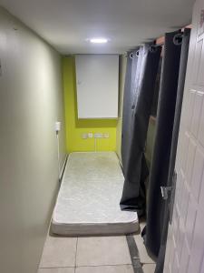 迪拜Capsule Partition at Elite Space的小房间设有白色床垫和墙上的白色板