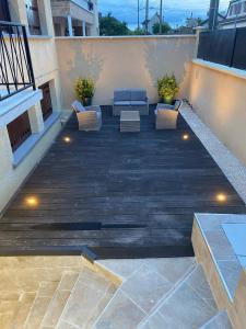 a patio with a couch and chairs on a balcony at G-Logement-Francilien Goussainville CDG in Goussainville