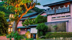 a pink building with a balcony on top of it at Omoideno Jinde in Izu