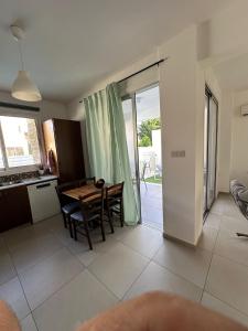 ペリヴォリアにあるHouse with 2 bedrooms and Poolのテーブルと椅子のあるキッチンとダイニングルーム