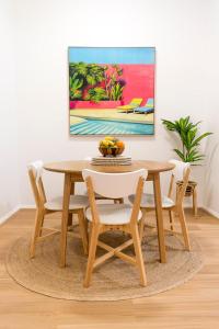 a dining room table and chairs with a painting on the wall at Charming One-Bedroom Apartment in Northbridge in Perth