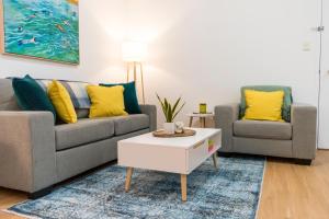 a living room with two couches and a coffee table at Charming One-Bedroom Apartment in Northbridge in Perth +31 photos