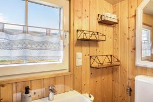 a bathroom with wooden walls and a sink and a window at Tinyhouse Alpakawiese in Schlitz +13 photos