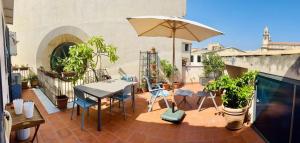 eine Terrasse mit Tisch und Sonnenschirm in der Unterkunft Terrazza Rosa Bianca in Palermo