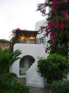 a white building with a staircase and pink flowers at Pleiades Modern Villa with Shared Pool in Ornos in Ornos
