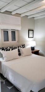 a bedroom with a large white bed and two windows at Pleiades Modern Villa with Shared Pool in Ornos in Ornos
