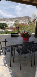 a wooden table and chairs on a patio with flowers at Pleiades Modern Villa with Shared Pool in Ornos in Ornos