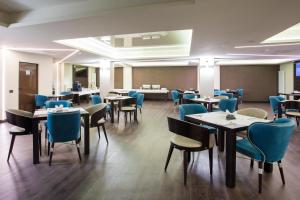 a dining room with tables and blue chairs at Old Town Hotel in Timişoara