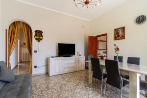 a living room with a dining room table and a television at Casa Venere Luxury Apartment in Giuggianello