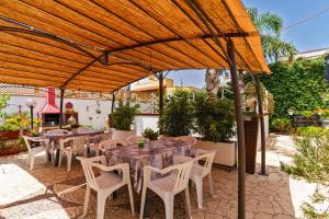 a patio with tables and chairs under a wooden umbrella at Casa Venere Luxury Apartment in Giuggianello