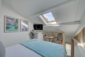 ein kleines Schlafzimmer mit einem Bett und einem Fenster in der Unterkunft The Originals Boutique, Clair Hôtel, Martigues in Martigues