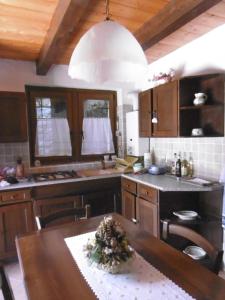 a kitchen with a wooden table and a kitchen with a counter at Baita "il Fieniletto" in Bannio