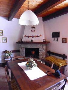 a dining room with a table and a fireplace at Baita "il Fieniletto" in Bannio