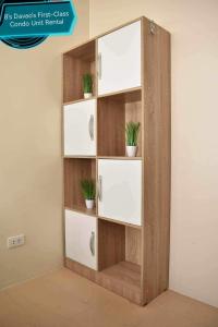a wooden book shelf with potted plants on it at 8's Davao's First-Class Condo Unit in Davao City