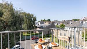 einen Tisch mit Speisen auf dem Balkon in der Unterkunft Le Vauban - A 15min à pied de la plage in Dinard