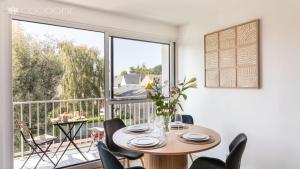 ein Esszimmer mit Tisch und Stühlen und einem großen Fenster in der Unterkunft Le Vauban - A 15min à pied de la plage in Dinard