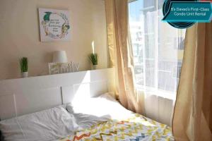 a bed in a room with a window at 8's Davao's First-Class Condo Unit in Davao City +14 photos