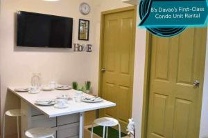 a room with a table with a tv on the wall at 8's Davao's First-Class Condo Unit in Davao City