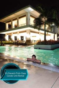 a person swimming in a swimming pool at a resort at 8's Davao's First-Class Condo Unit in Davao City